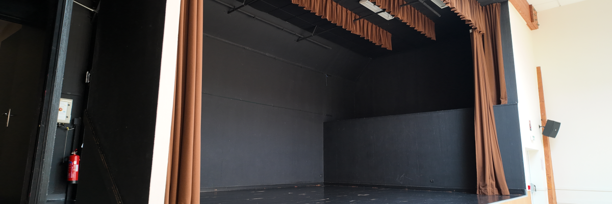 Scène de théâtre avec rideaux, éclairages et sol noir.