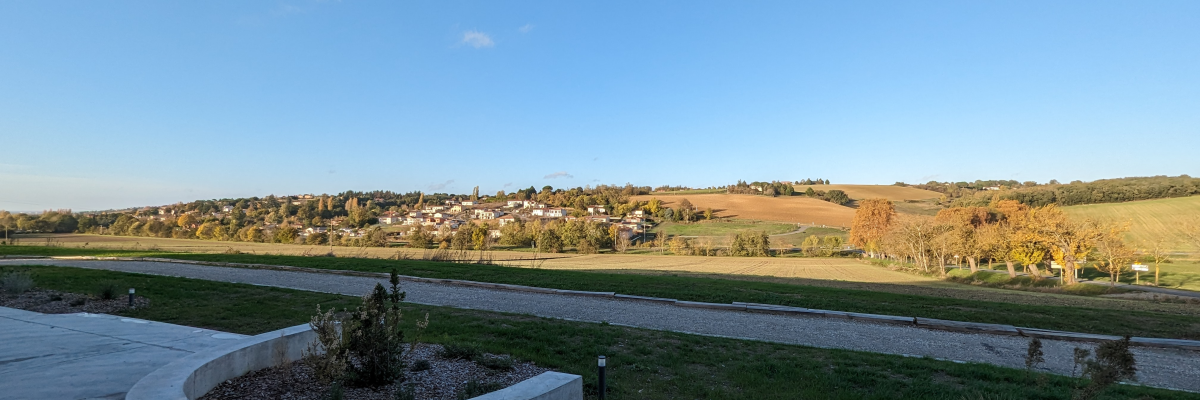 Piste cyclable, paysage rural, ciel dégagé.