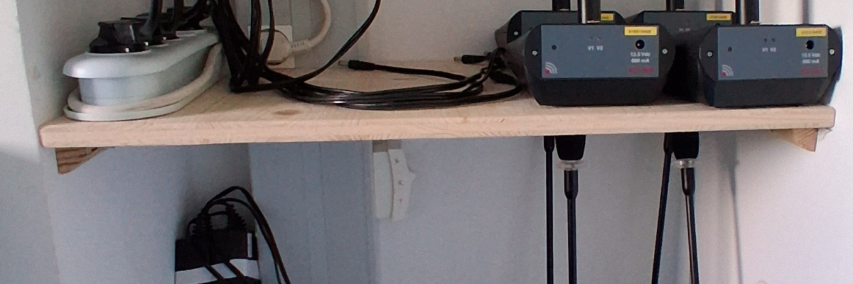 Shelves with microphones, cables, and audio equipment.