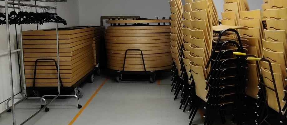 Salle avec étagères, chariots et rangées de caisses en plastique.