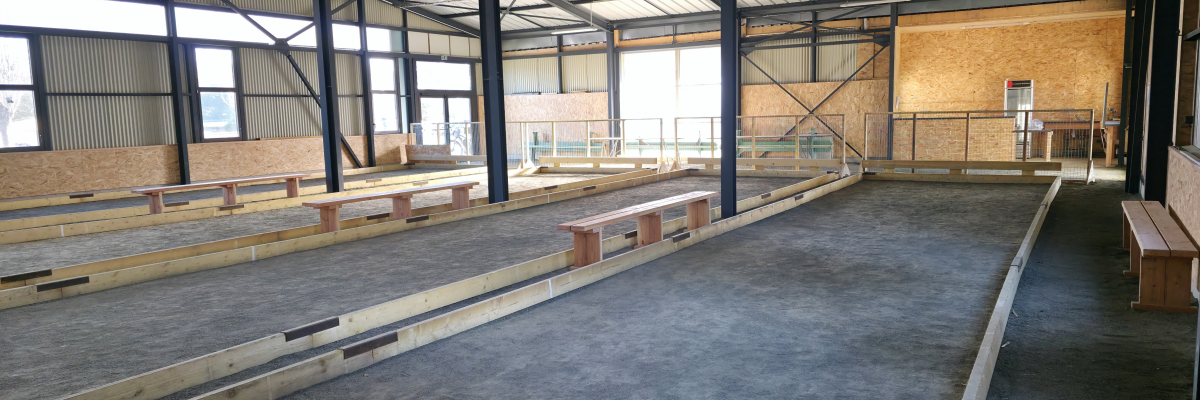 Atelier avec bancs de travail, étagères et structure métallique.