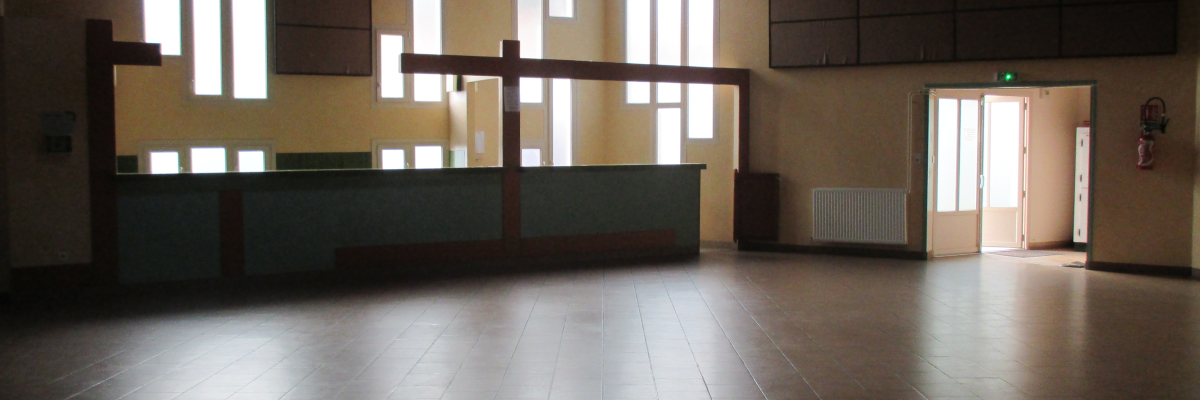 Salle avec sol carrelé, grands fenêtres, comptoir, radiateur et lumière suspendu.