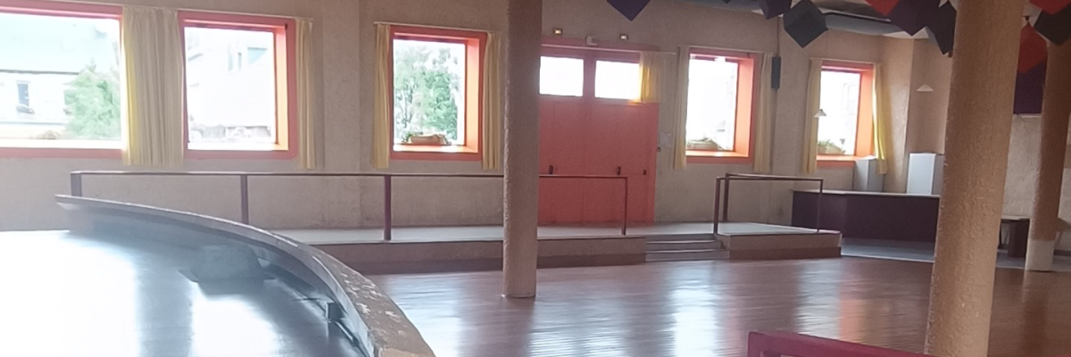 Salle avec sol en bois, escaliers, rampes et cubes suspendus.