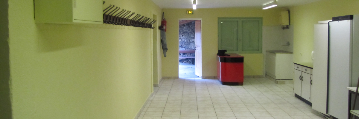 Pièce avec placard, porte-manteau, comptoir, réfrigérateur, évier et porte.