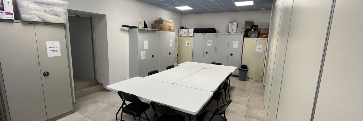 Salle avec table, chaises, armoires et étagères.