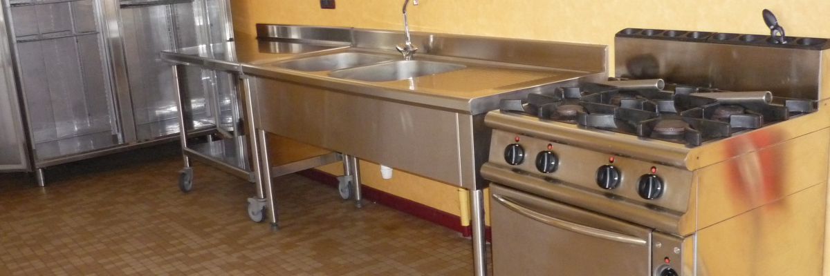 Cuisine équipée, avec rangements métalliques, plans de travail, évier.