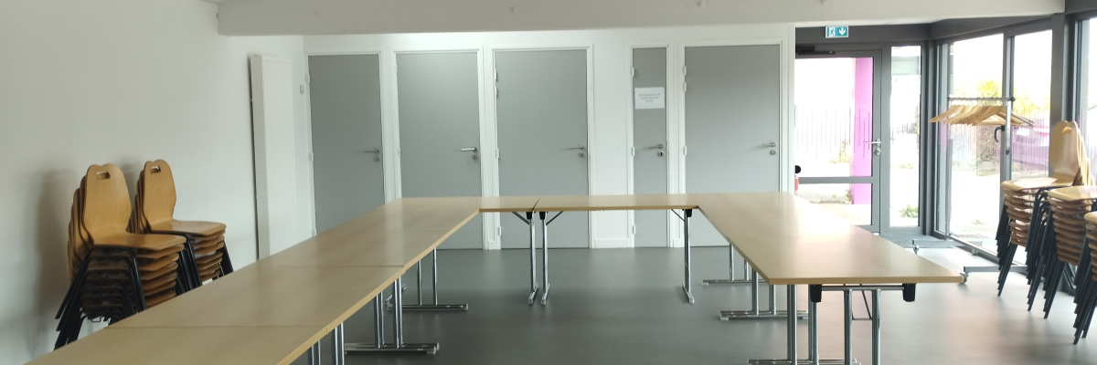 Salle avec tables, chaises, et lumières.