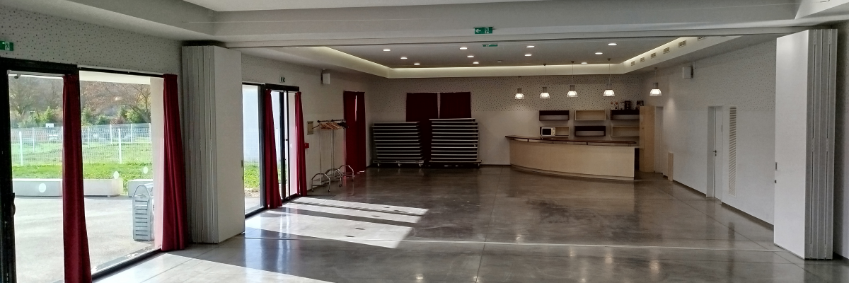 Salle spacieuse avec comptoir, étagères, portes et fenêtres.