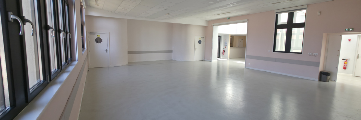 Salle vide avec portes, fenêtres, et extincteur.