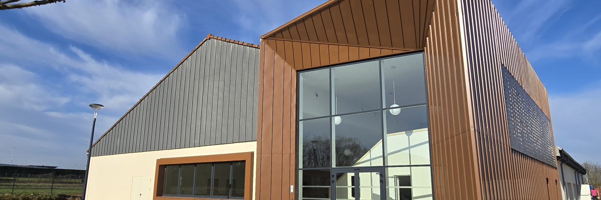 Bâtiment moderne avec façade en bois et grandes baies vitrées.