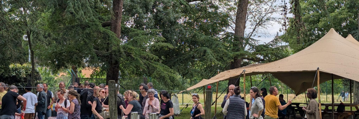 "Événement en plein air avec tentes, tables, et gens."