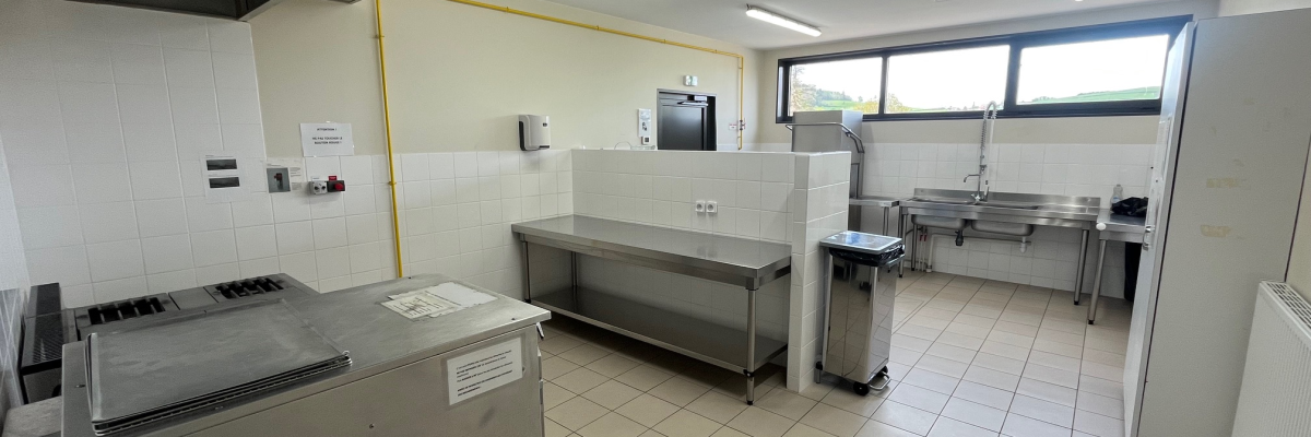 Cuisine avec hôtesses, plans de travail, fours, évier.