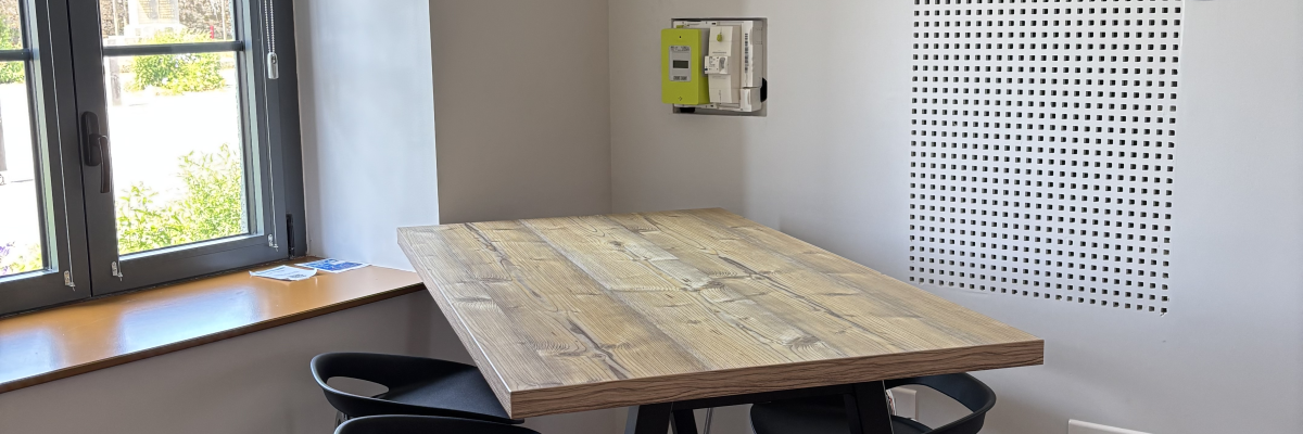 Pièce avec table, tabourets et fenêtre.