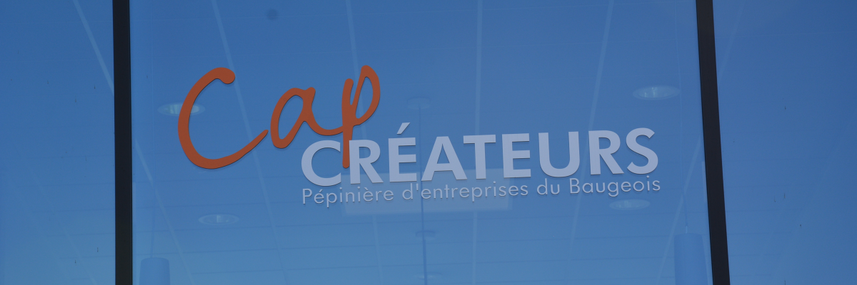 Vitre reflétant "Cap Créateurs" et intérieur avec éclairage et plafond.