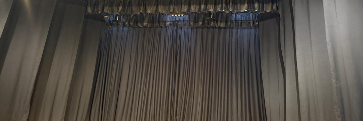 Scène de théâtre avec rideaux et éclairage.