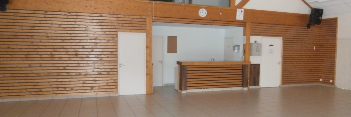 Salle avec comptoir, horloge, porte et haut-parleurs.