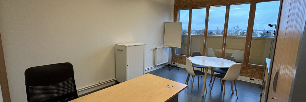 Bureau avec table, chaises, tableau blanc, armoire.