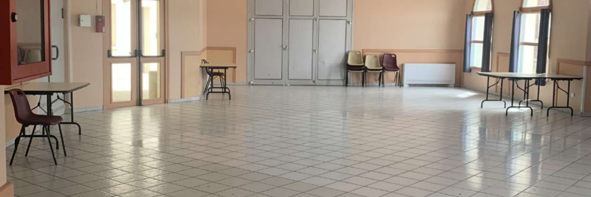 Salle avec tables, chaises, et portes.