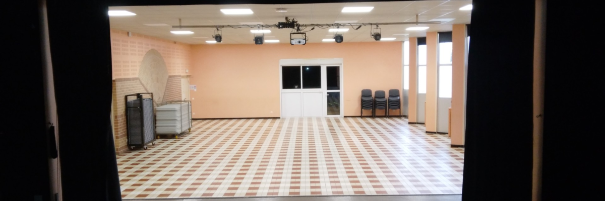 Salle avec projecteur, chaises, porte, fenêtre, spots et planchers carrelés.