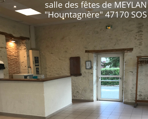 Salle avec comptoir, porte, mur en pierre et équipement de cuisine.