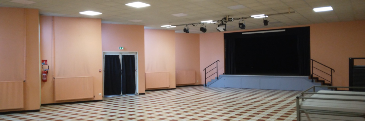 Salle avec scène, éclairages, et porte.