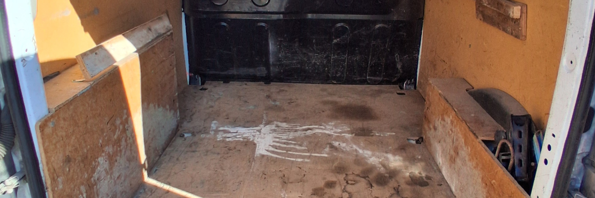 Intérieur d'un fourgon avec sièges et panneaux de porte visibles.