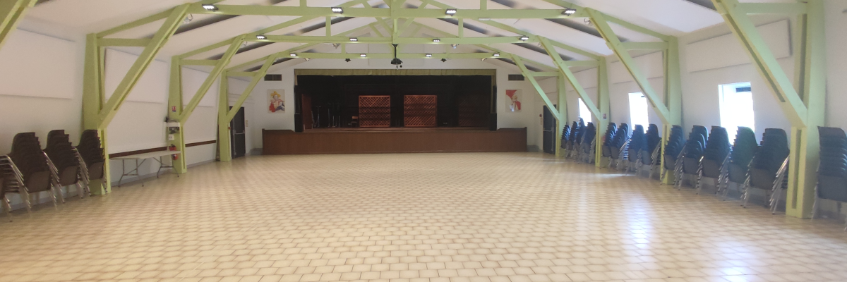 Salle avec chaises, podium, structure métallique, éclairage.