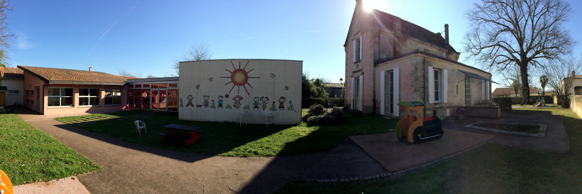 Cour d'école avec bâtiments, aire de jeux et terrains de sport.