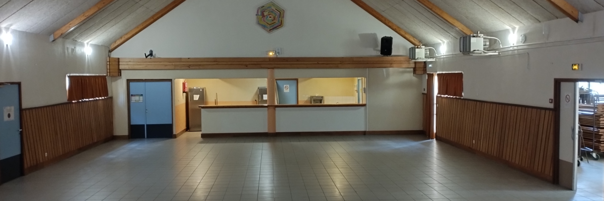 Salle avec comptoir, porte et sol carrelé sous un toit haut en ardoise.