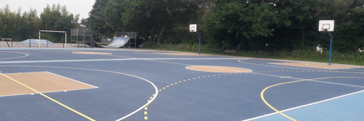 Terrain de basket avec paniers, lignes de jeu et toboggan.