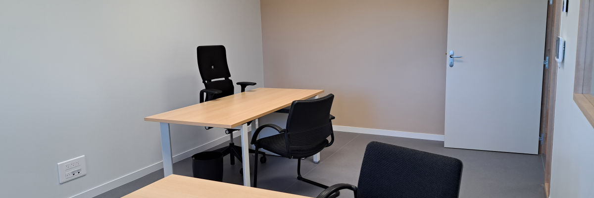 Bureau, chaises, porte, interrupteurs muraux.