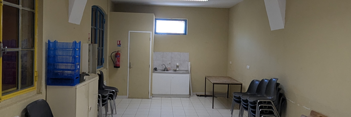 Couloir avec chaises, table, lavabo et distributeur.