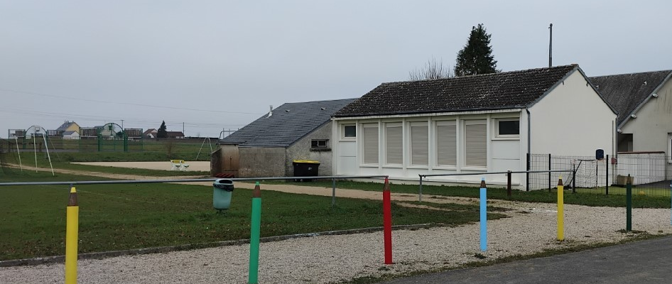 Bâtiments, terrains de sport, poubelles, poteaux colorés, passage piéton.