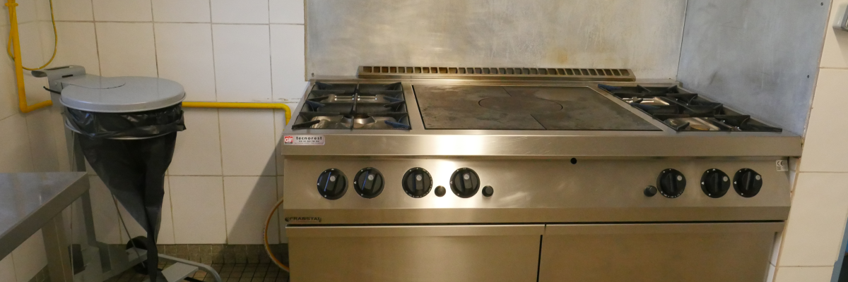 Cuisine avec plaque de cuisson, poubelle et hottes.