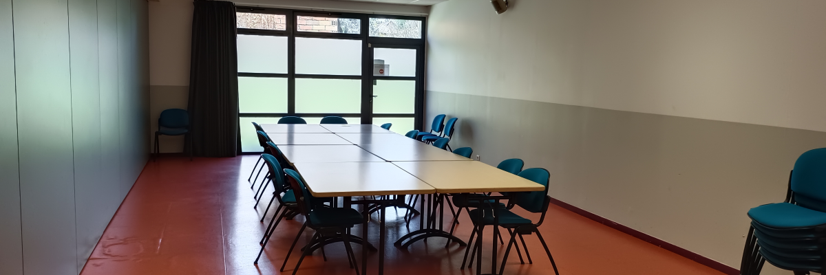 Salle avec table, chaises, fenêtres et porte.