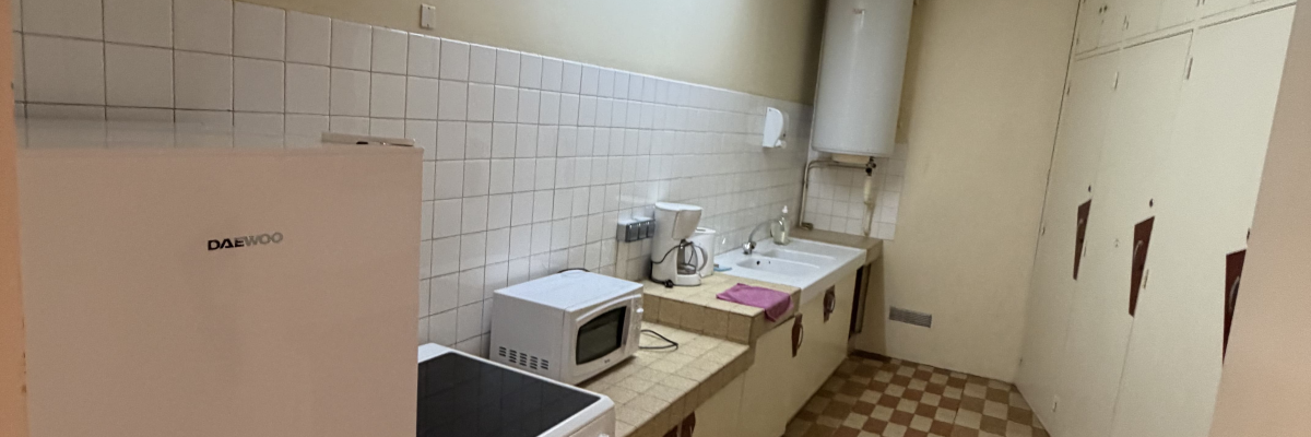 Cuisine avec carrelage, placards, évier, four et réfrigérateur.