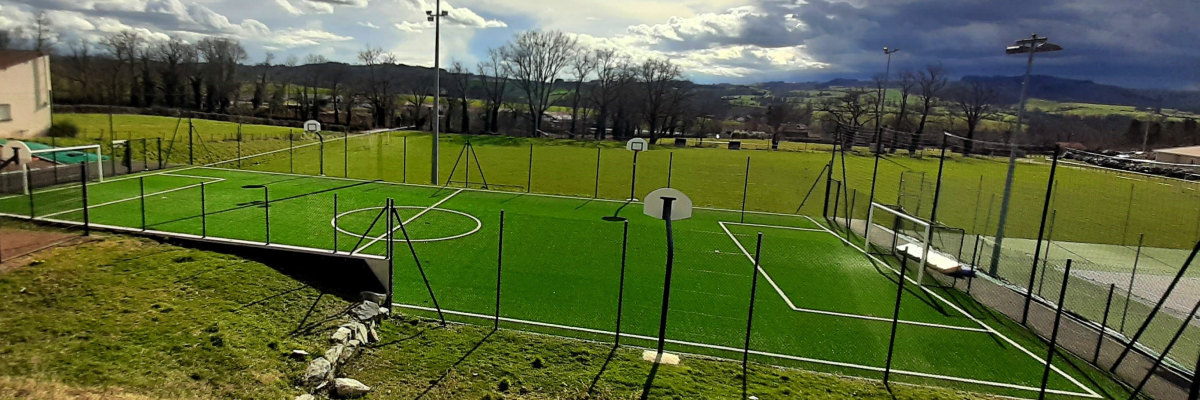 Terrain de foot avec filets, buts et projecteurs.