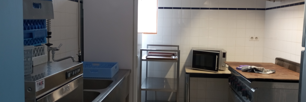 Cuisine avec évier, lave-vaisselle, réfrigérateur, four, micro-ondes et hotte.