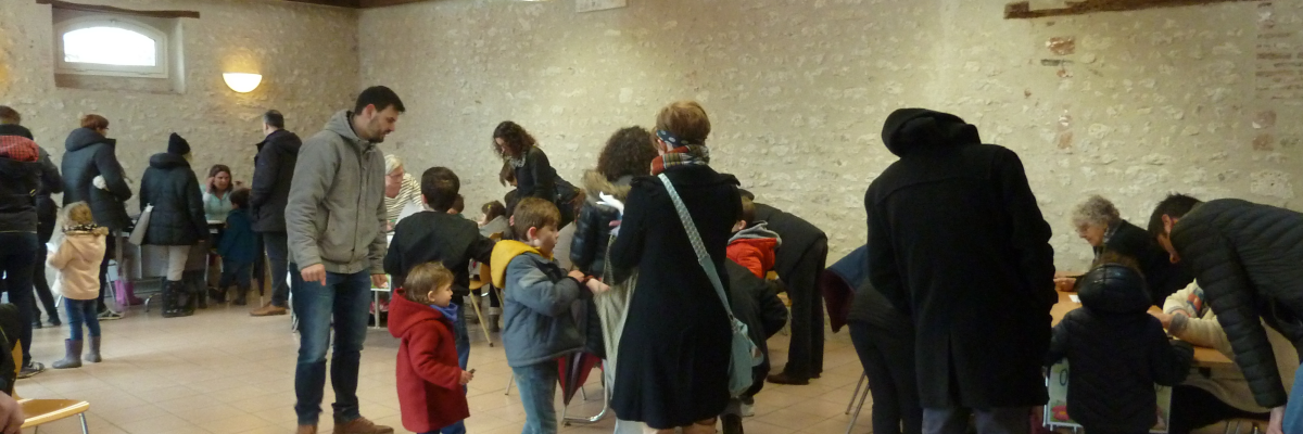 Salle avec tables, chaises, et personnes debout et assises.