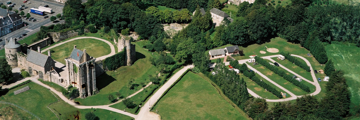 Vue aérienne d'un château, de jardins et de bâtiments environnants.