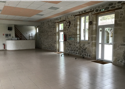 Pièce vide avec murs en pierre, portes, escaliers et carrelage.