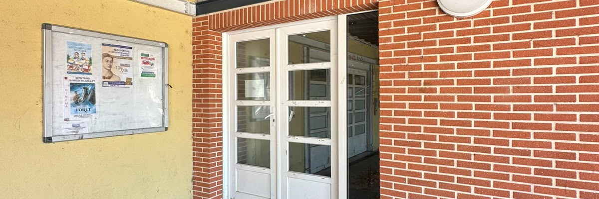 Entrée avec porte, rampe et affiche.