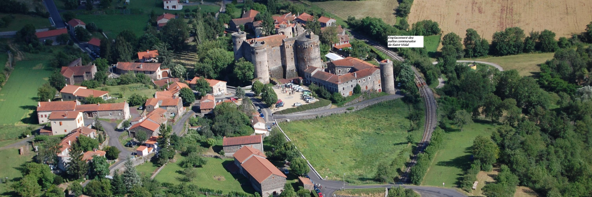 Village médiéval avec château, maisons, routes, voitures et champs.