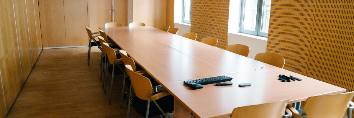 Salle de réunion avec table, chaises, clavier, souris.