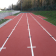 Piste d'athlétisme rouge avec lignes blanches.