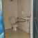 Cabine de toilettes avec WC, lavabo, porte et serrure.