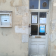 Porte blanche avec vitre, boîte aux lettres et affiches.