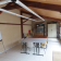 Salle avec table, chaises, tableau blanc, écran, paperboard et étagères.