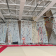 Salle d'escalade avec murs d'escalade, tapis de sécurité, cordes et harnais.