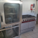 Cuisinière à gaz, four et étagère de rangement dans une cuisine.